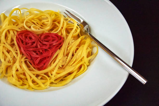 red linguine heart-shaped arranged - teigwaren imagens e fotografias de stock