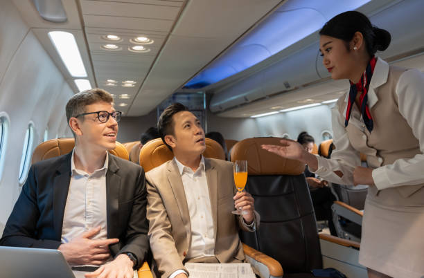 istock Flight attendant serving orange juice to businessman on plane 2022963074