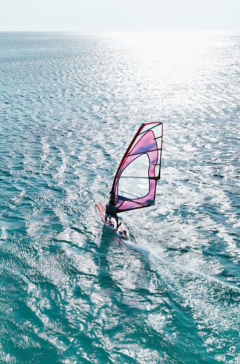 Windsurfing in a calm day with clear blue sky and Mediterranean Sea