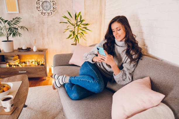 istock A young woman texting messages on her mobile phone while enjoying at home 2023009091