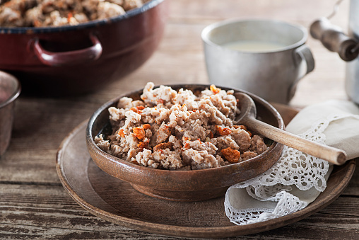 Slovenian traditional dish buckwheat mush served with pan-fried pork cracklings and lard and bowl warm milk close up shoot