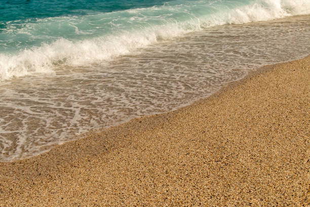 Gentle wave crashing against the beach on a sunny summer day. Los Muertos Beach in Almería.