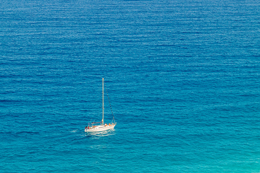Overhead view of a sailboat sailing through the Mediterranean Sea. Los Muertos Beach, Almeria, Spain.