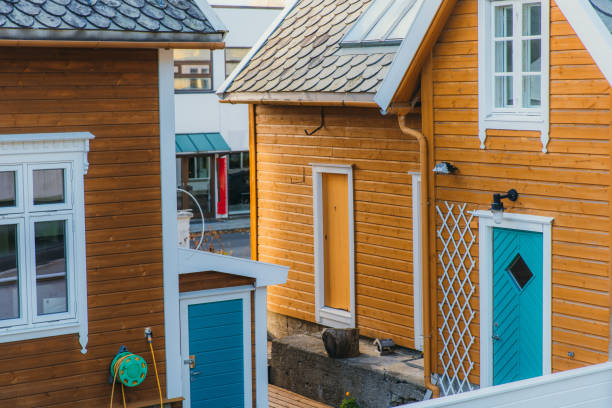 View of group of yellow buildings with blue doors in Scandinavian city of Ulsteinvik, Norway