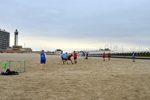 Blankenberge, West-Flanders, Belgium - February 17, 2024: male adult friends playing a game of mini football on the beach