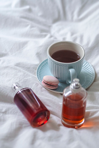 A cup of tea with iced coffee and macarons in the foreground