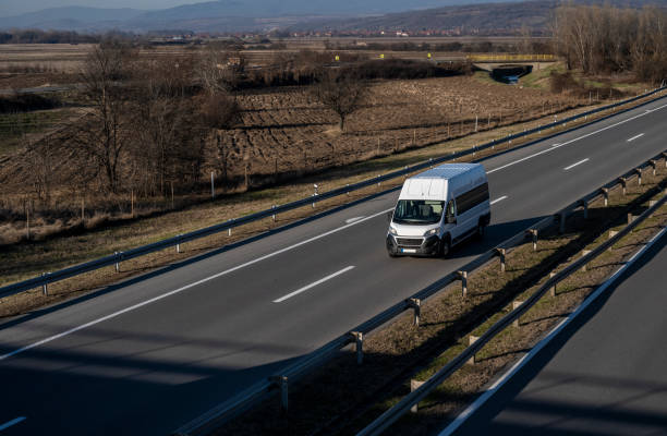 istock White modern delivery small shipment cargo courier van moving fast on motorway road to city urban suburb 2023077341
