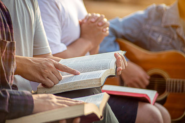 istock Christian family groups holding hands praying with Holy Bible. 2023089618