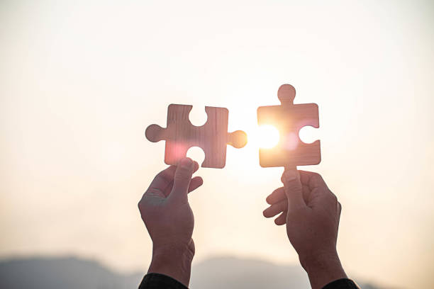 istock Two hands connect couple puzzle piece with sunset background. 2023090160