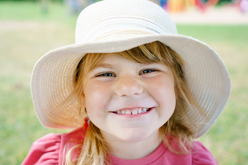 Portrait of a child girl playing with friends on the beach