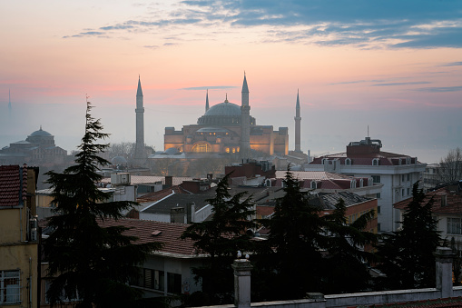 View of the Hagia Sophia Grand Mosque from the roof of the house against the background of the dawn sky on a foggy morning, Istanbul, Turkey