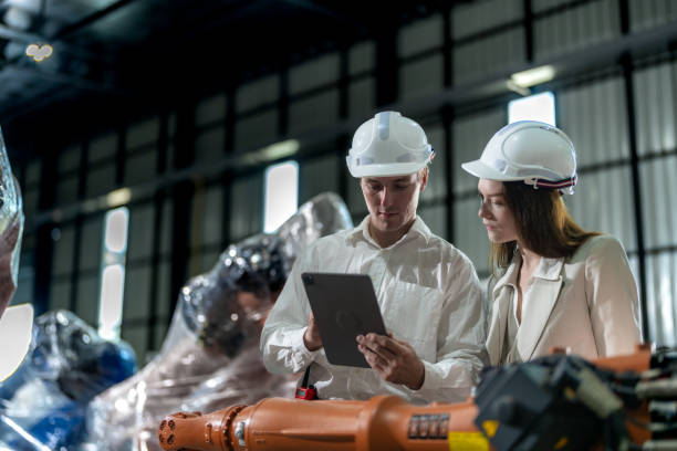 istock Factory engineers inspecting on machine with smart tablet. Worker works at machine robot arm. The welding machine with a remote system in an industrial factory. Artificial intelligence concept. 2023128022