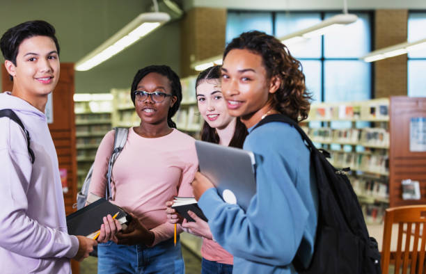 istock Four multiracial high school students in library 2023139126
