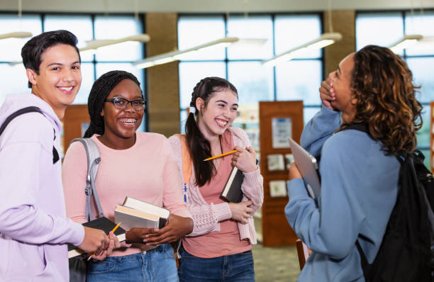 istock Four multiracial high school students in library 2023139142