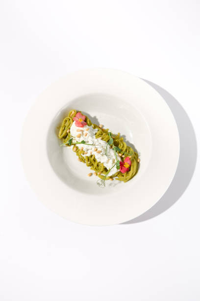 istock Top View of Spaghetti with Pesto Sauce and Stracciatella Cheese, Artistic Plating on White Background for Culinary Presentations 2023147218
