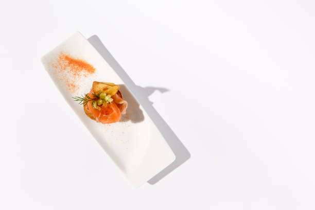 istock Salmon profiterole on a white ceramic platter with a creative paprika dusting, captured in a bright setting 2023147769