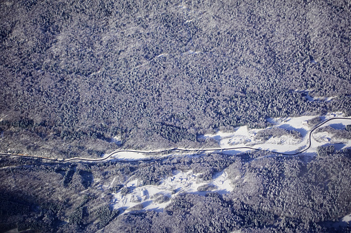 Aerial view over snow capped forests and mountains in Switzerland