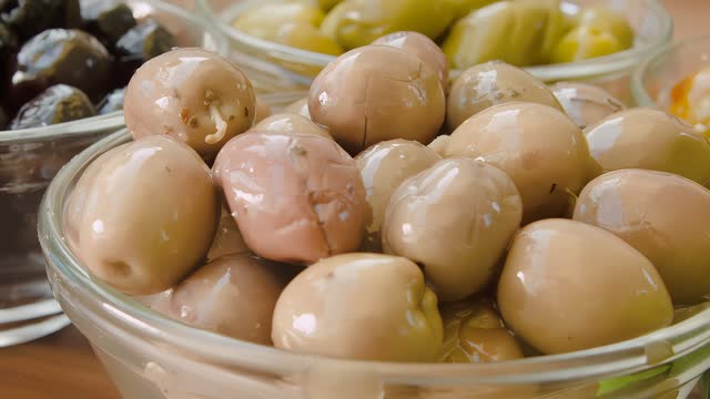 White pickled olives in a glass bowl