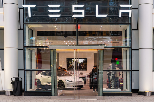 Boston, MA, US- January 15, 2024: Entrance to Tesla electric automobile showroom with customers looking at vehicles