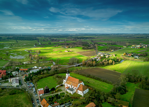 Idyllic countryside green fields, blue sky and village houses on horizon natural landscape