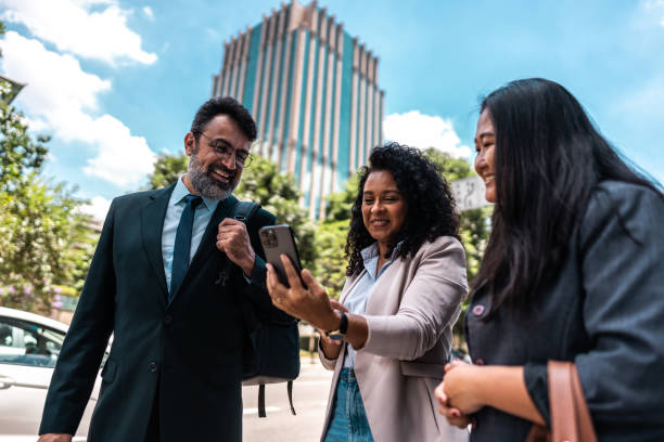 istock Coworkers using the mobile phone in the street 2023188517
