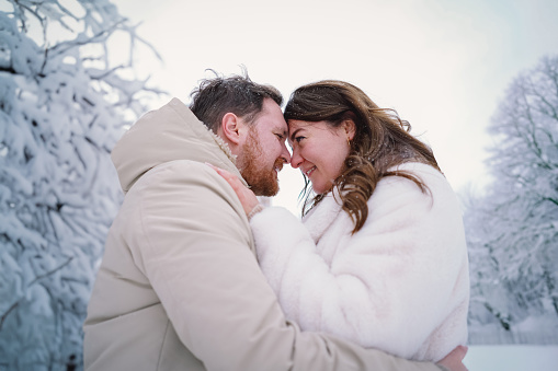 Loving couple on a snowy winter field. Happy together. Happy Valentine's Day