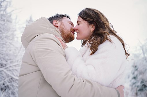 Loving couple on a snowy winter field. Happy together. Happy Valentine's Day