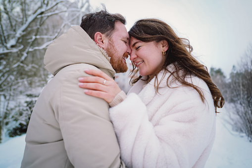 Loving couple on a snowy winter field. Happy together. Happy Valentine's Day