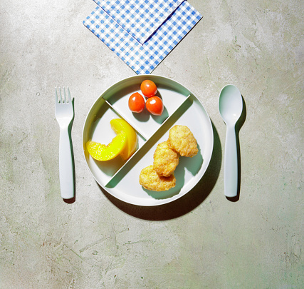 Kid's meal on a child's plate with fruit and vegetable