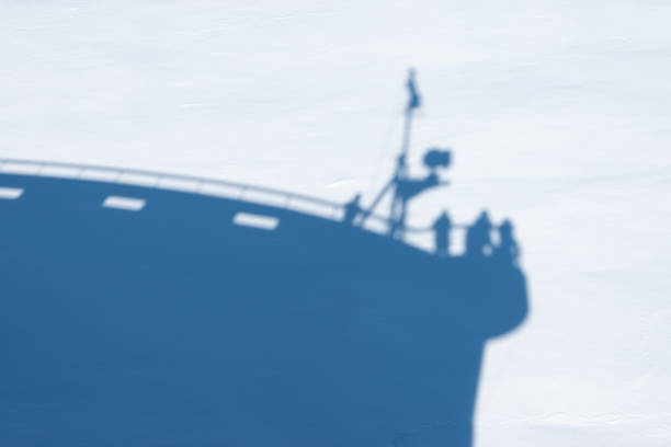 Silhouette of luxury expedition cruise ship on snowy sea ice background. Travel image of cruise ship that made an exceptional ice landing in Antarctica.