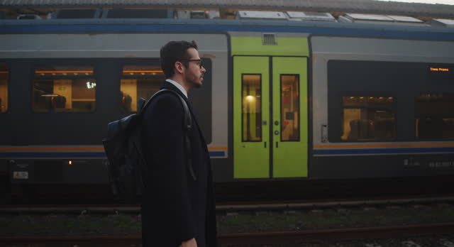 A young adult businessman is walking in a train station