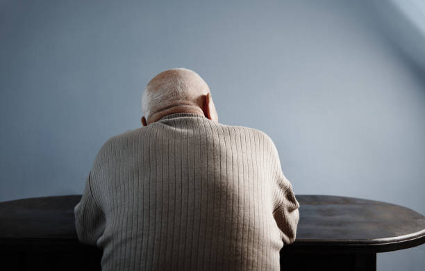 Back view on senior man sitting at the table