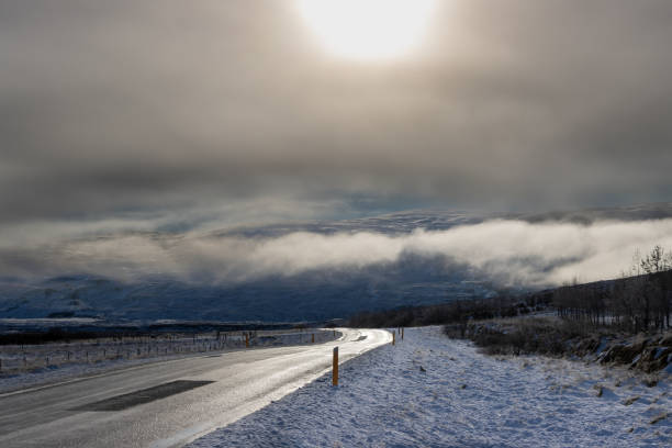 Autumn country with littlebit snow in the autumn. Fields and pastures along the road. Cloudy sky. Nordausturvegur, North Iceland.