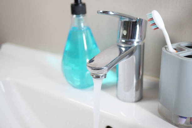 water pouring from a faucet tap slow motion .