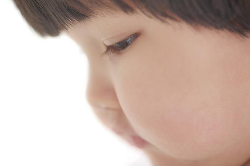 Side view on the child on studio background. Close-up photo