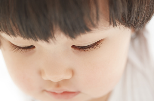 Close-up photo of pensive child on a white background