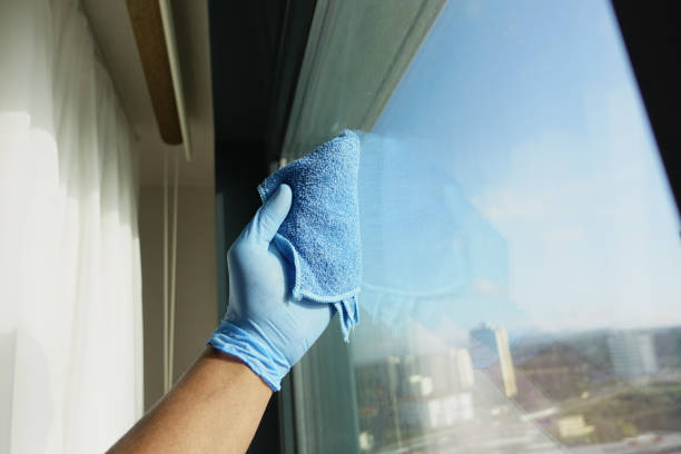 istock hand in blue glove cleaning window with blue rag 2023322832