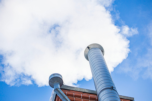 Metal chimney of a geothermal power station with stainless steel pipe structure with smoke and steam