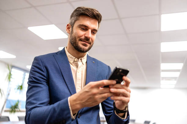istock Smart looking manager in business suit using smart phone in meeting room. 2023383674