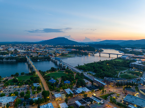 Aerial photo of Chattanooga Tennessee taken from Northshore overlooking Coolidge Park, the Tennessee River, 3 Bridges, with Downtown and the silhouette of Lookout Mountain in the background during twilight.
