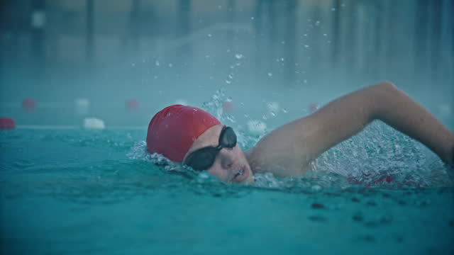 SLO MO Determined Sporty Woman Wearing Cap and Goggles while Swimming in Foggy Pool at Resort
