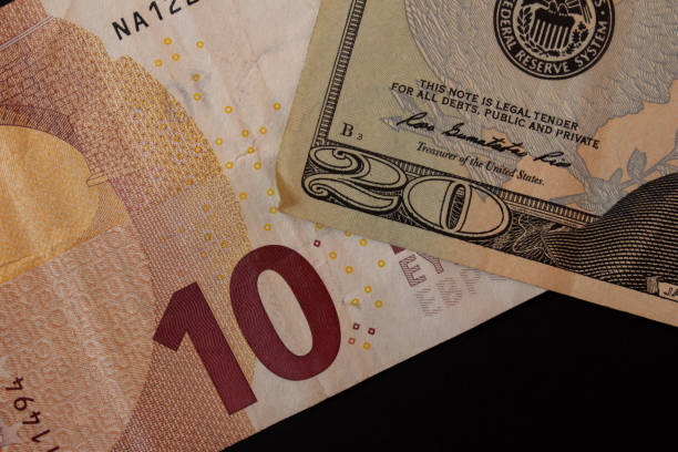 10 euro and 20 dollar bills on black background. Closeup photo.