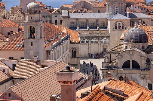 Dubrovnik, Croatia - June 27, 2023: Aerial view of Old Town (Stari Grad) from medieval city wall by Adriatic Sea. Dubrovnik Cathedral, Clock tower and dome of Church of St. Blaise