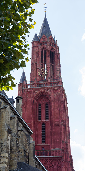 Daytime view of the 79 meter high red clock tower of the Gothic medieval Saint John Church (Sint-Janskerk in Dutch), located next to the 'Basilica of Saint Servatius' at the famous Vrijthof square in Maastricht, the current church dates from the 14th and early 15th century - it is listed as a  Rijksmonument (national heritage site) since 1966 under no. 27704