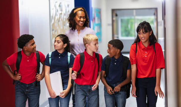 istock Teacher with middle school students walking in hallway 2023554699