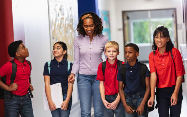 istock Teacher with middle school students walking in hallway 2023554700