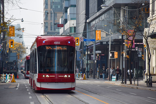 October 30, 2022 - Toronto, Ontario, Canada: Red streetcar downtown Toronto on King Street West and John Street