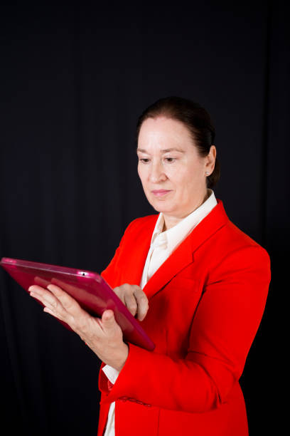 Caucasian business woman looking at digital tablet. Black  background