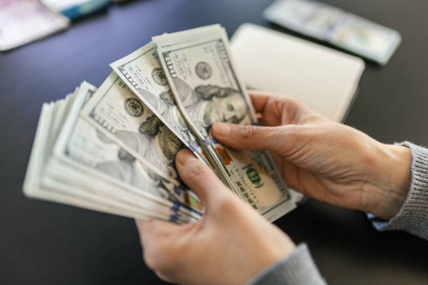 istock Woman counting dollar bills 2023651827