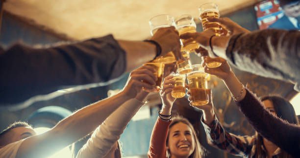 Happy friends group drinking beer at brewery bar restaurant - Friendship concept with young people enjoying time together and having genuine fun at cool vintage pub stock photo